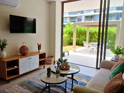 a living room with a couch and a tv at Lujoso Apto con Piscina Privada y salida a playa in Cartagena de Indias