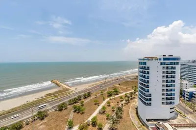 a building next to a beach with the ocean at Suite de Lujo Frente al Mar CB1525 in Cartagena de Indias