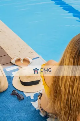 a woman laying next to a pool with a hat and sunglasses at Suite de Lujo Frente al Mar CB1525 in Cartagena de Indias