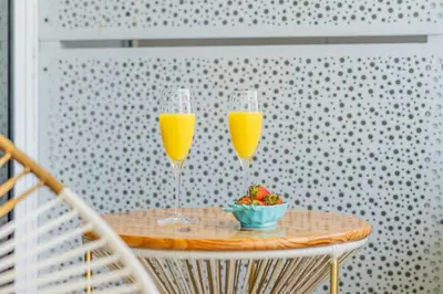 two glasses of orange juice and a bowl of fruit on a table at MQ903 | Jacuzzi & hamaca · Vista espectacular in Cartagena de Indias