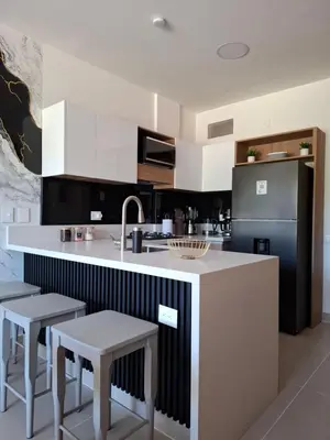 a kitchen with a white counter and some stools at Baia Kristal - Vacaciones Cartagena Colombia in Cartagena de Indias