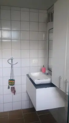 a white bathroom with a sink and a mirror at Balcones en Bello Horizonte in Santa Marta