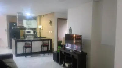 a living room with a television and a kitchen at Balcones en Bello Horizonte in Santa Marta