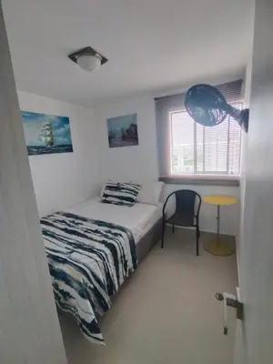 a bedroom with a bed and a table and a window at Sol y Brisa 811 in Cartagena de Indias