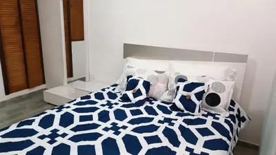a bedroom with a blue and white bed with pillows at Isabela House in Barranquilla