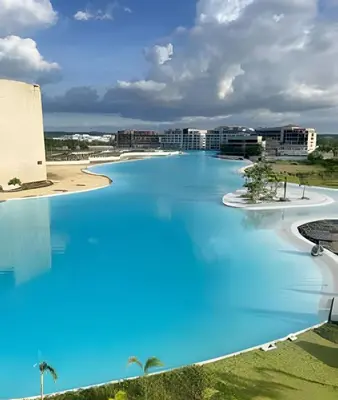 a large pool of blue water with buildings in the background at Vista a Laguna de Kristal + Bote inflable in Los Arrayanes