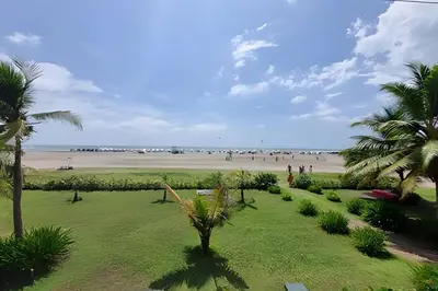a park with palm trees and a beach with people at 1 Dormitorio y terraza Morros. Vista mar in Cartagena de Indias