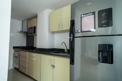 a kitchen with wooden cabinets and a refrigerator at Apartamento 1 dormitorio Morros. Vista Mar y Acceso Playa in Cartagena de Indias
