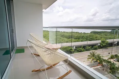 a white chair sitting on a balcony with a large window at Apartamento 1 dormitorio Morros. Vista Mar y Acceso Playa in Cartagena de Indias