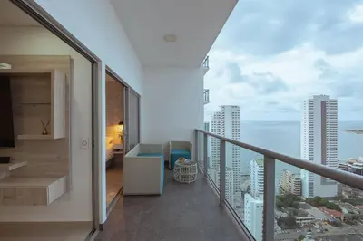 a room with a balcony with a view of the ocean at Apartment With Beautiful View In Infinitum in Cartagena de Indias