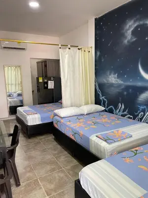 a bedroom with two beds and a painting on the wall at Habitaciones Melany in Coveñas
