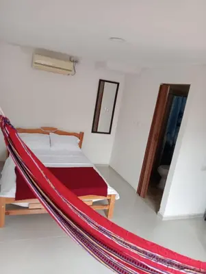 a room with a bed and a hammock in it at Habitaciones frente al mar in Carretal