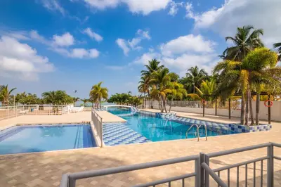 a pool at the resort with palm trees at Magico Apartamento Frente al Mar 3 Habitaciones AR134 in Coveñas