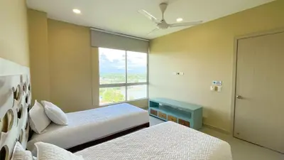 two beds in a room with a window at Magico Apartamento Frente al Mar 3 Habitaciones AR134 in Coveñas
