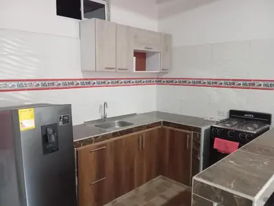 a small kitchen with a sink and a refrigerator at Apartamentos el farol in Ciénaga