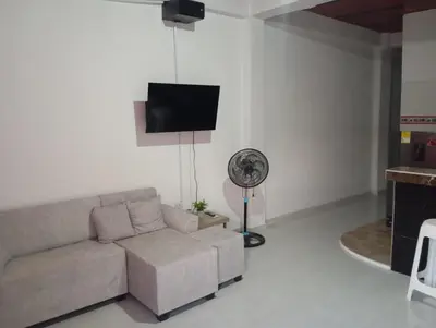 a living room with a couch and a fan at Apartamentos el farol in Ciénaga