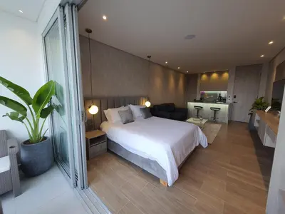 a bedroom with a large bed and a living room at Moderna suite con balcón y vista al lago y al mar in Cartagena de Indias