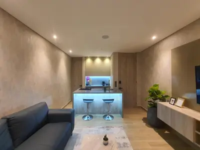 a living room with a couch and a kitchen at Moderna suite con balcón y vista al lago y al mar in Cartagena de Indias