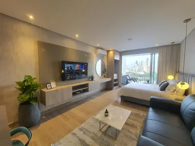 a room with a bed and a tv and a couch at Moderna suite con balcón y vista al lago y al mar in Cartagena de Indias