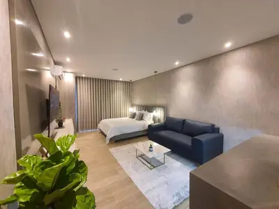 a living room with a blue couch and a bed at Moderna suite con balcón y vista al lago y al mar in Cartagena de Indias