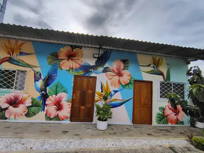 a mural on the side of a building with flowers at Villa Colibrí in Santa Marta