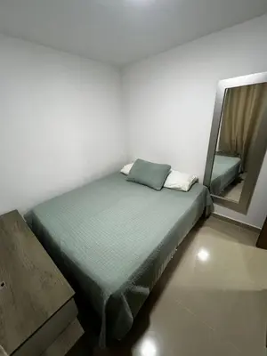 a small bedroom with a bed and a mirror at Duplex Penthouse Rooftop Lounge in Barranquilla