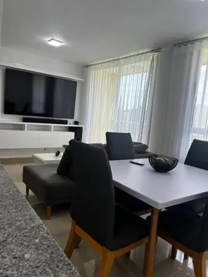 a living room with a table and chairs and a television at Duplex Penthouse Rooftop Lounge in Barranquilla