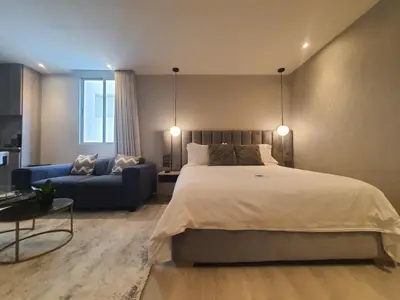 a bedroom with a large bed and a blue couch at Moderna suite frente al lago cerca a la playa in Cartagena de Indias