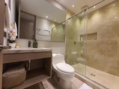 a bathroom with a toilet and a glass shower at Moderna suite frente al lago cerca a la playa in Cartagena de Indias