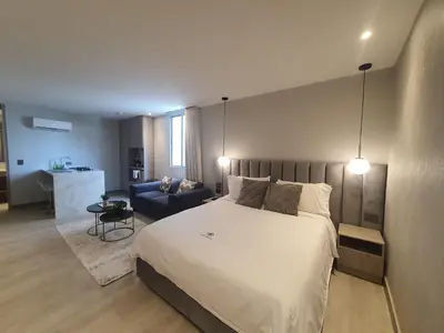 a bedroom with a large bed and a blue couch at Moderna suite frente al lago cerca a la playa in Cartagena de Indias