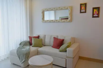 a living room with a white couch with colorful pillows at Luxury 2-Bedroom Apartment with Breathtaking Ocean Views in Cartagena de Indias
