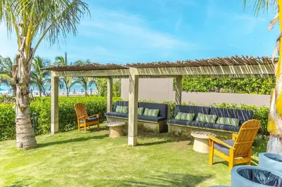 a pergola with a blue couch and chairs in a yard at Luxury 2-Bedroom Apartment with Breathtaking Ocean Views in Cartagena de Indias