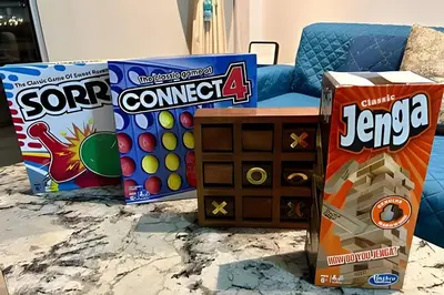 a living room with a couch and a box of games at 1 Alcoba Hermosa vista a la laguna + bote inflable in Los Arrayanes