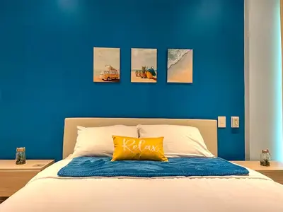 a blue bedroom with a bed with a yellow pillow at 1 Alcoba Hermosa vista a la laguna + bote inflable in Los Arrayanes