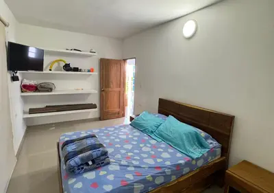 a bedroom with a bed with blue pillows on it at Cabaña de ensueño en Coveñas in Puerto Viejo