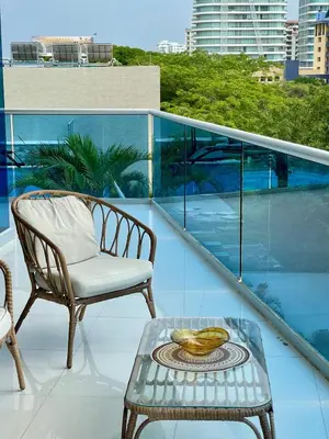 a chair and a table on a balcony at Lujo y espacio Bello Horozonte gran apartamento hasta 10 personas in Santa Marta