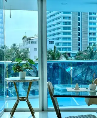 a table and chair in a room with a window at Lujo y espacio Bello Horozonte gran apartamento hasta 10 personas in Santa Marta