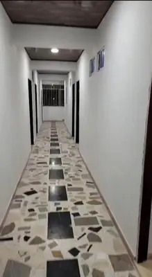 an empty hallway with a tile floor and white walls at CARTAGENA BOQUILLA BEACH HOSTEl in Cartagena de Indias
