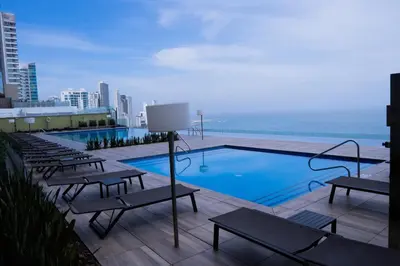 a swimming pool on top of a building with benches at Disfruta el espectáculo de la bahía in Cartagena de Indias