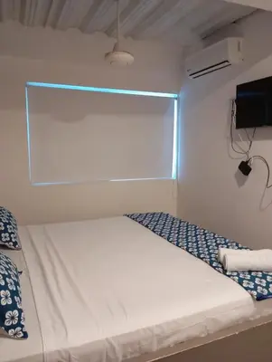 a white bed in a room with a window at Hotel Nativo Manzanillo in Cartagena de Indias