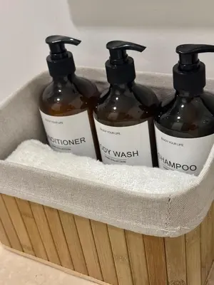 a basket with four bottles of soap and towels at Apartamento de lujo en Santa Marina Santa Marta in Santa Marta
