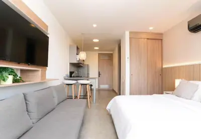 a bedroom with a bed and a couch and a kitchen at Apartamento de lujo en Santa Marina Santa Marta in Santa Marta