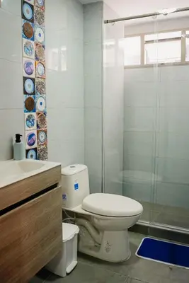 a bathroom with a toilet and a glass shower at Apartamento Laguito Cartagena in Cartagena de Indias