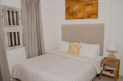a bedroom with a bed with a striped blanket and a window at Comfortable apartment in the historic center in Cartagena de Indias