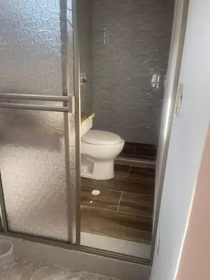 a bathroom with a toilet and a glass shower door at Apartamento M&M in Coveñas