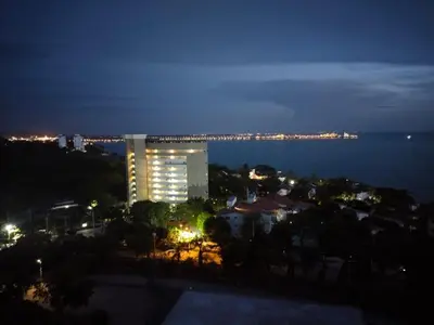 a lit up building at night with the ocean at Estrene en Santa Marta vía Barranquilla a 10 minutos aeropuerto, acceso y vista al mar in Santa Marta