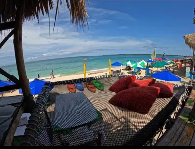 a beach with chairs and umbrellas and the ocean at Hostal Ananda in Playa Blanca