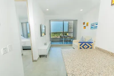 a white living room with a couch and a table at Elemnt Rentals in Santa Marta