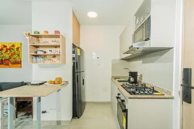 a kitchen with white walls and a stove top oven at Elemnt Rentals in Santa Marta