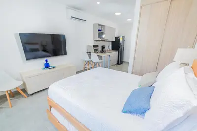 a bedroom with a bed and a flat screen tv at Elemnt Rentals in Santa Marta